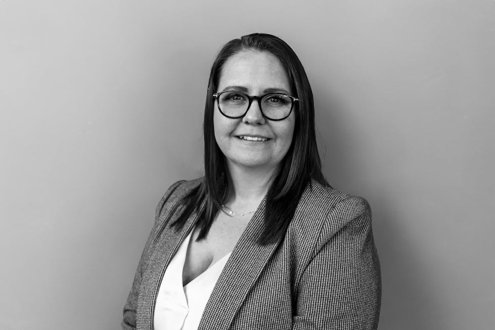 a person wearing glasses and smiling at the camera