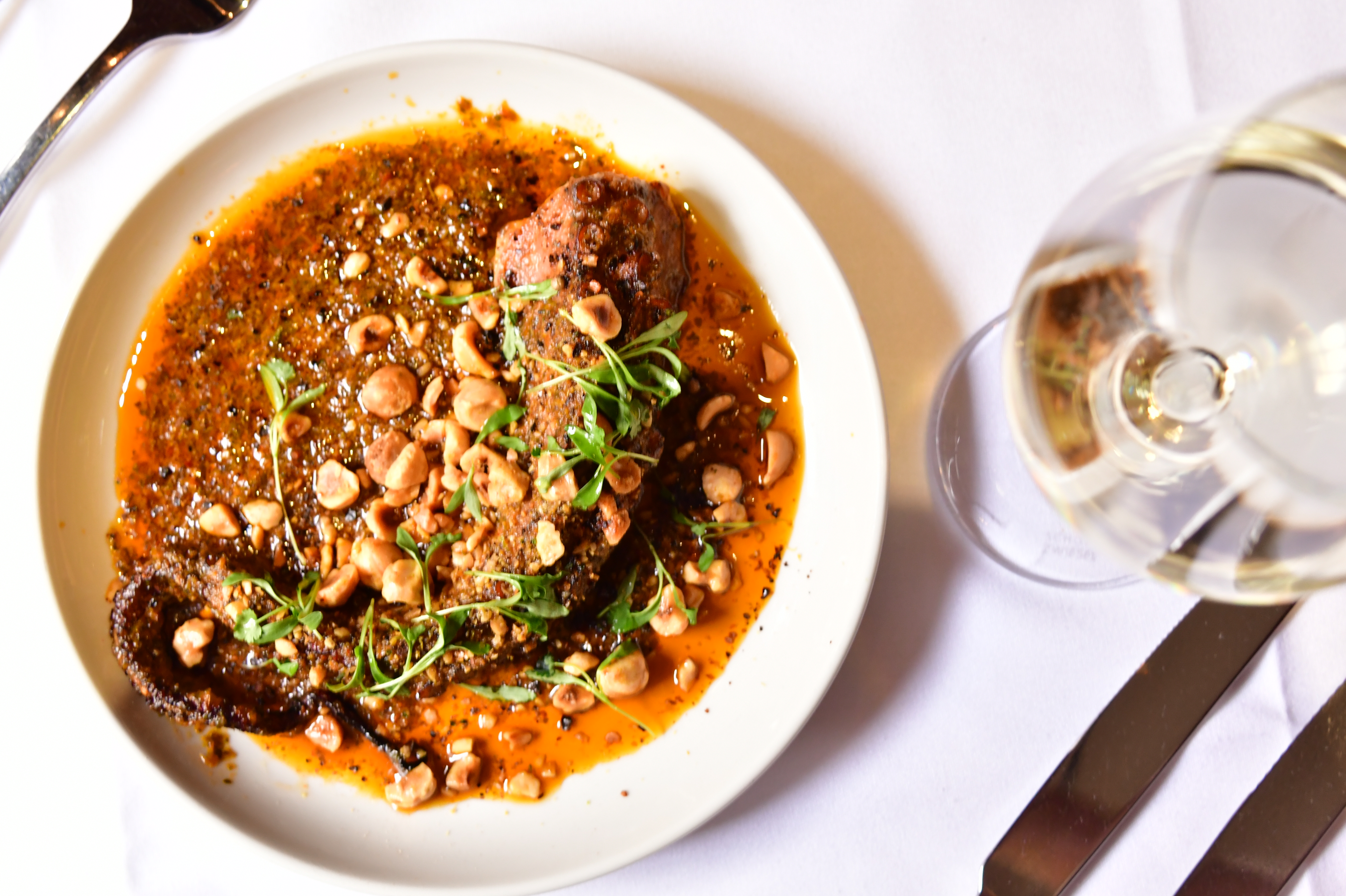 A plate of food featuring a serving of meat alongside a portion of beans