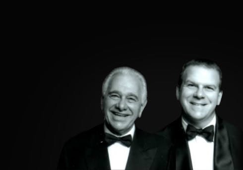 Vic and Tilman J. Fertitta wearing a suit and tie