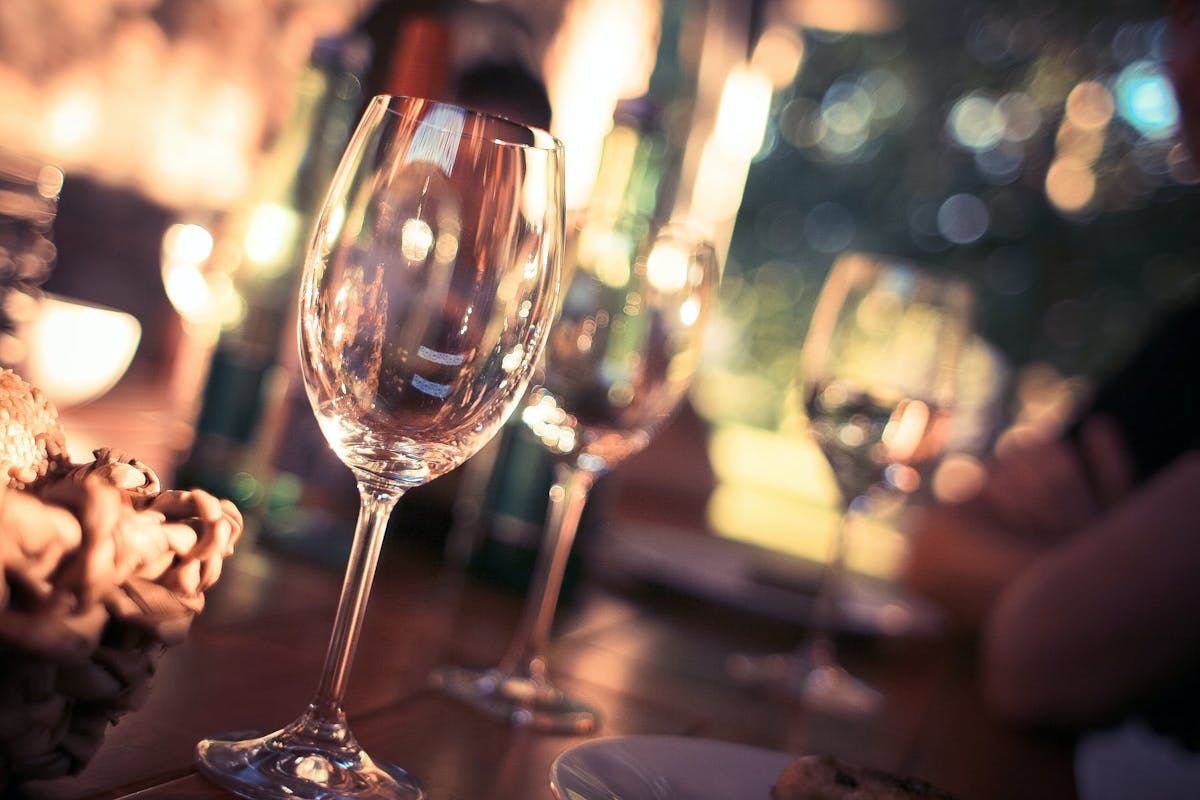 a person sitting at a table with wine glasses