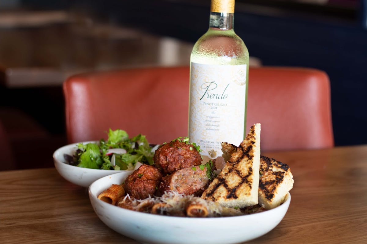 a bottle of wine sitting on top of a plate of food