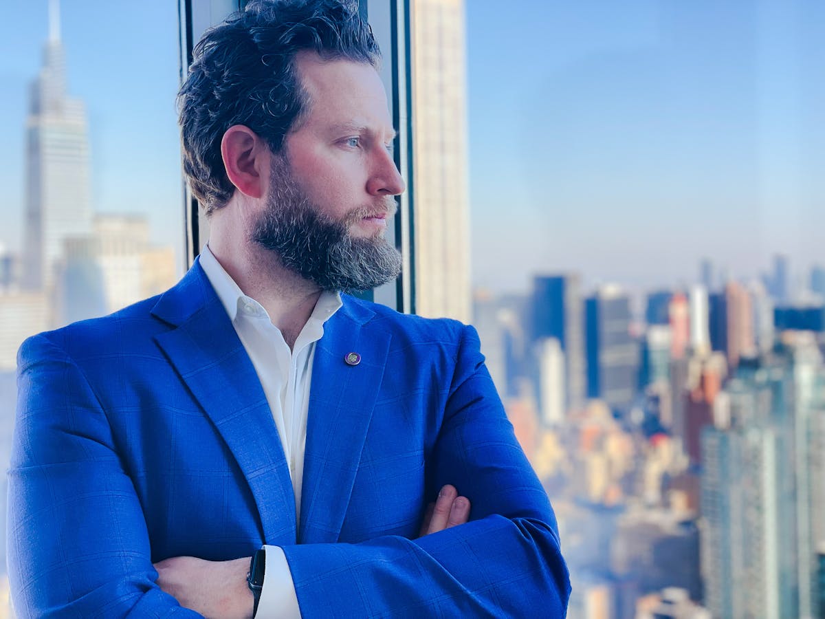 a man wearing a blue jacket is looking at the camera