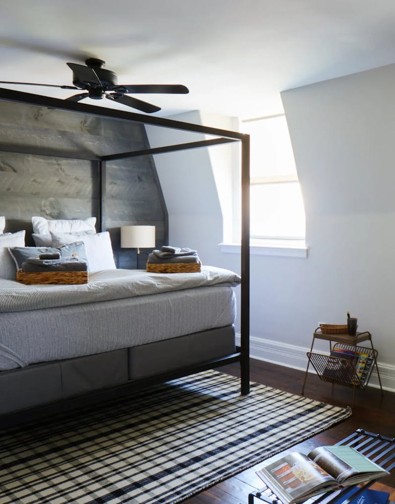 a bedroom with a bed and desk in a room