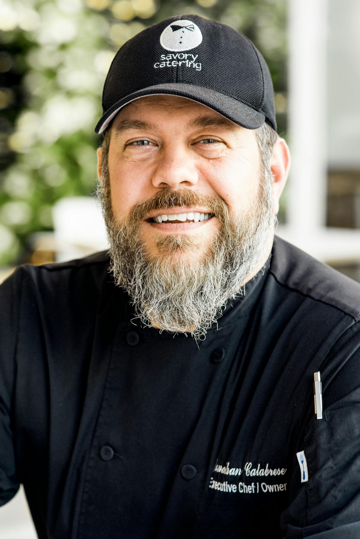 a man wearing a hat and smiling at the camera