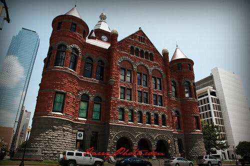 a large brick building with Dallas County Courthouse in the background