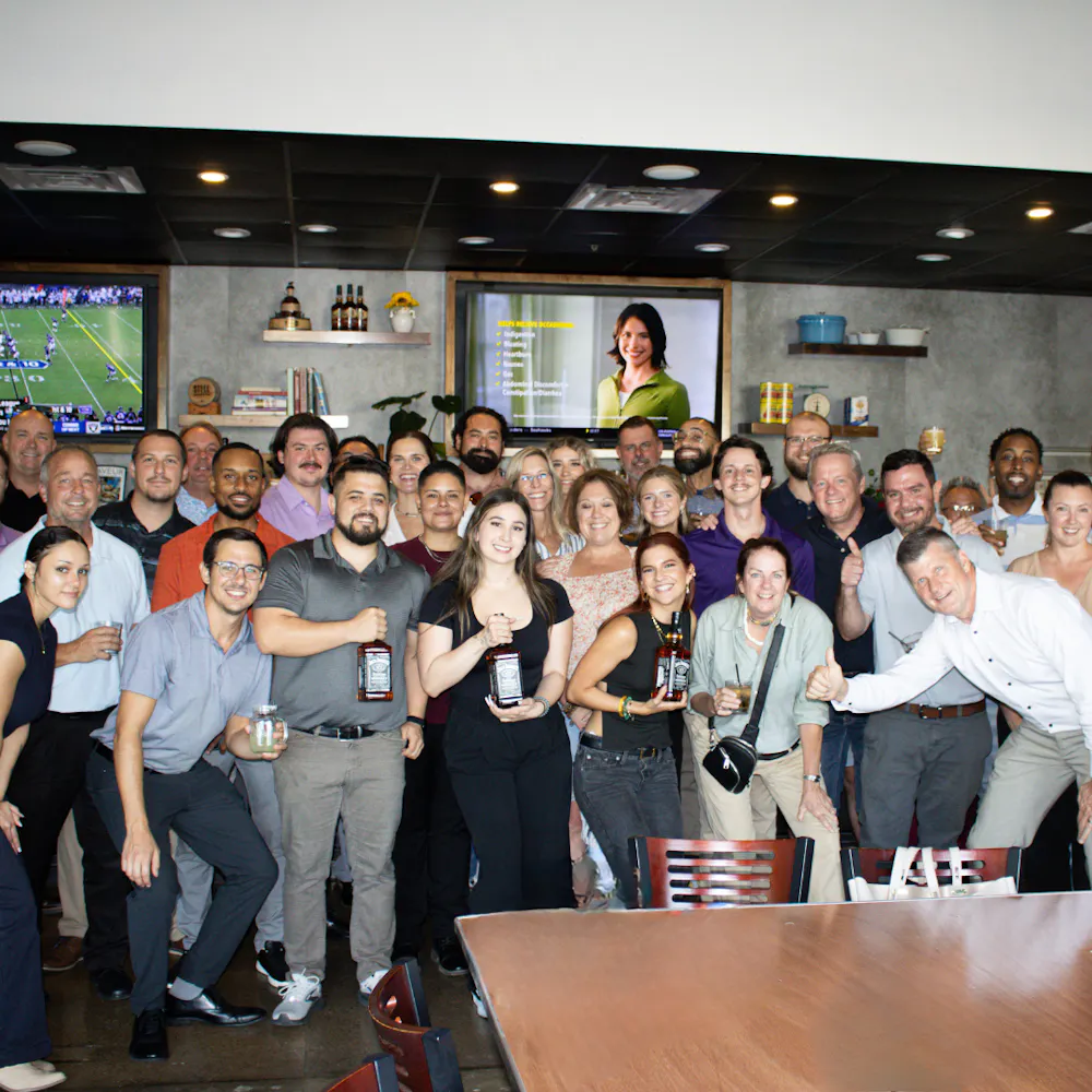 a group of people standing in front of a crowd posing for the camera at gatherings event space in dallas