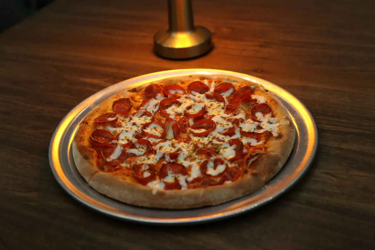 a pizza sitting on top of a wooden table