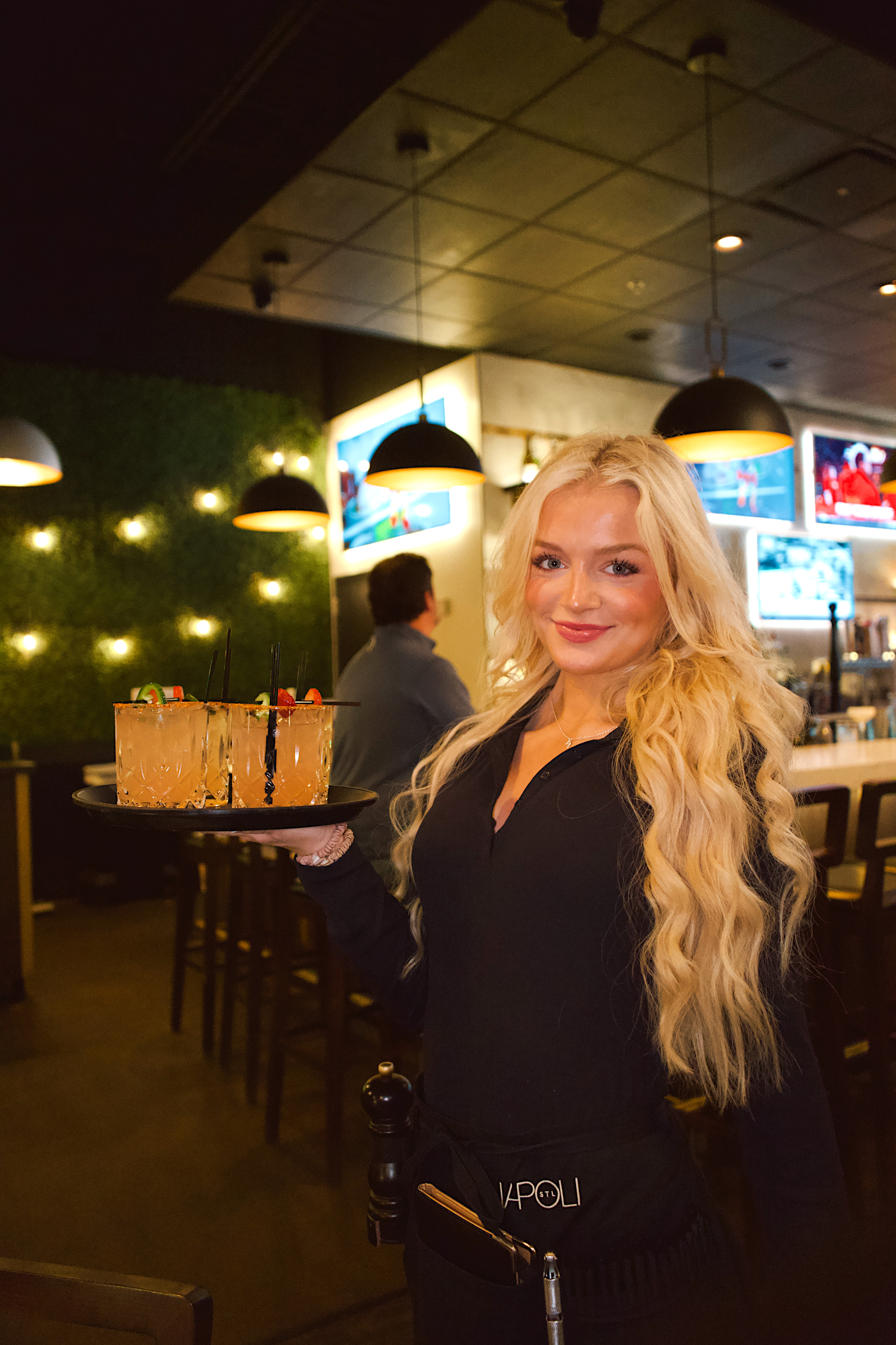 a woman holding a tray of drinks