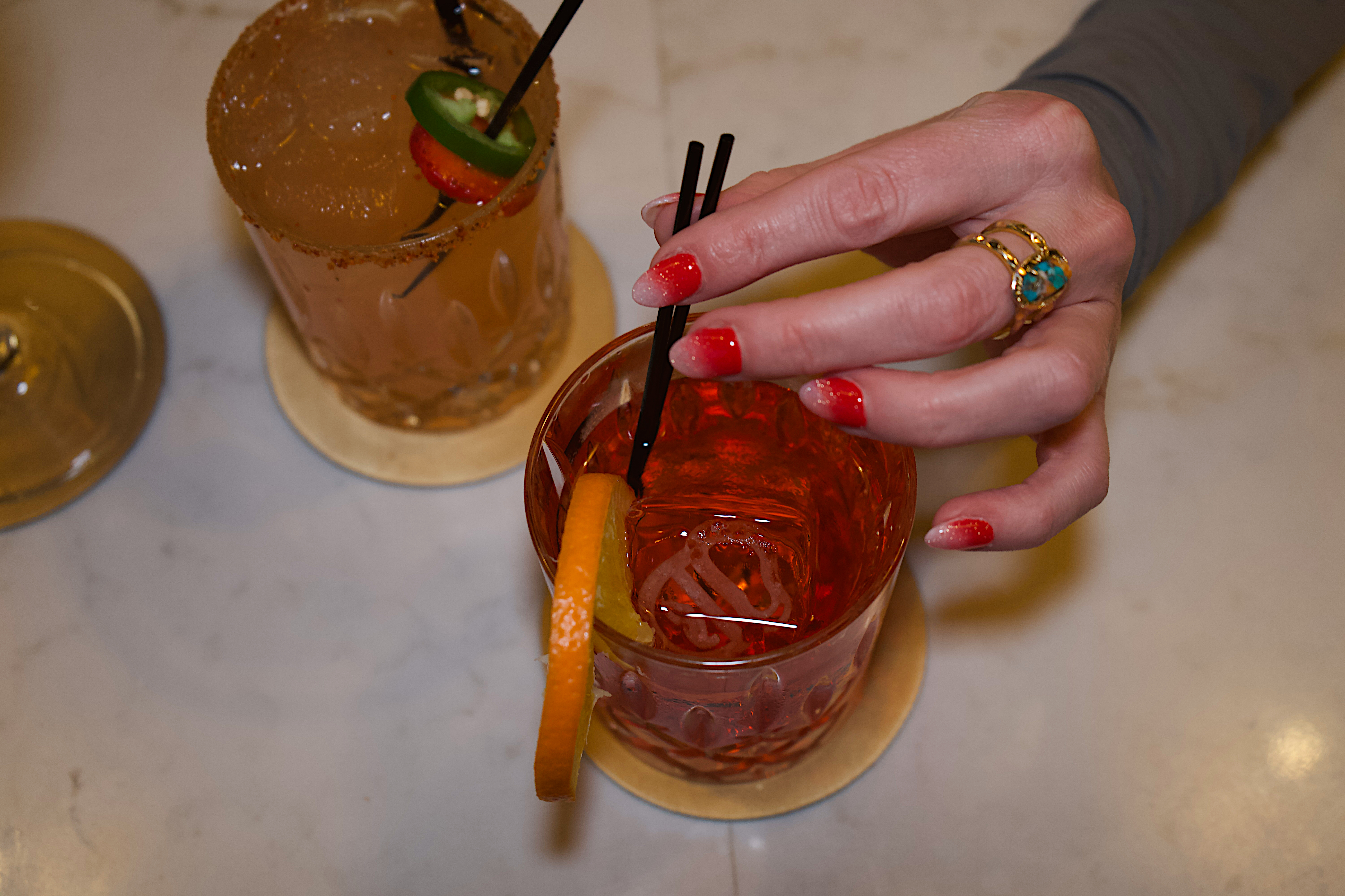 a hand holding a drink with straws