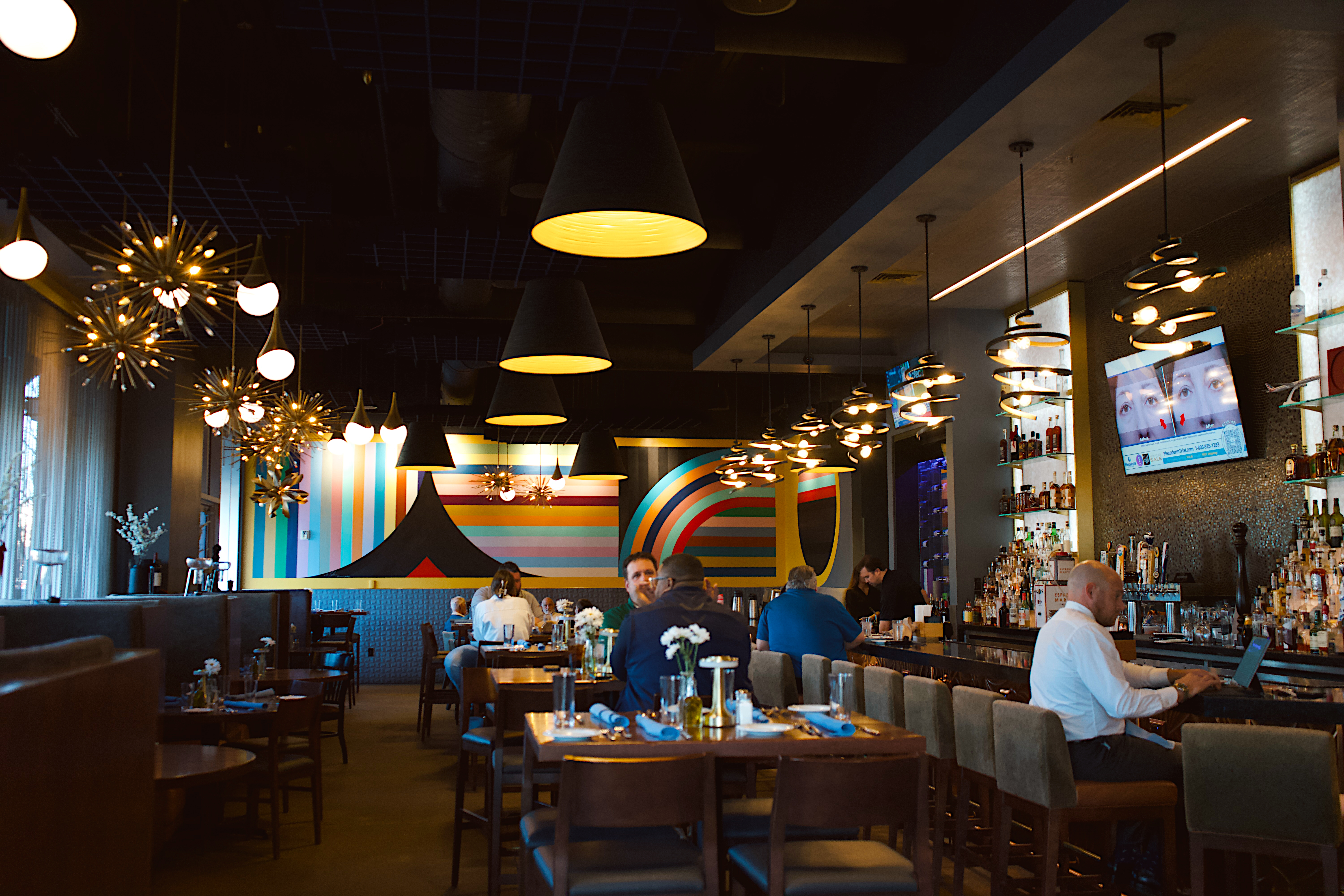a group of people sitting at tables in a restaurant