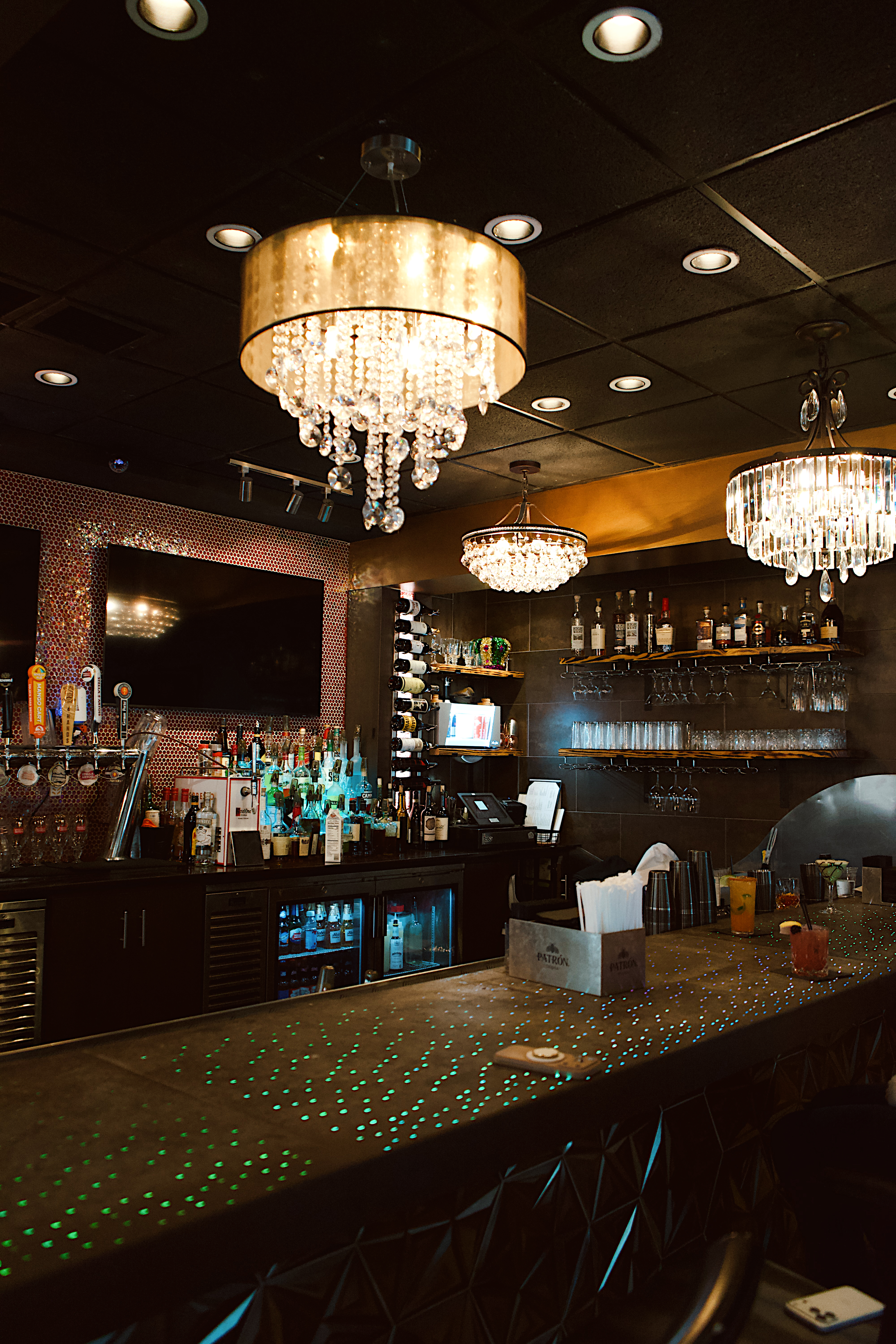 a bar with a bar counter and chandeliers