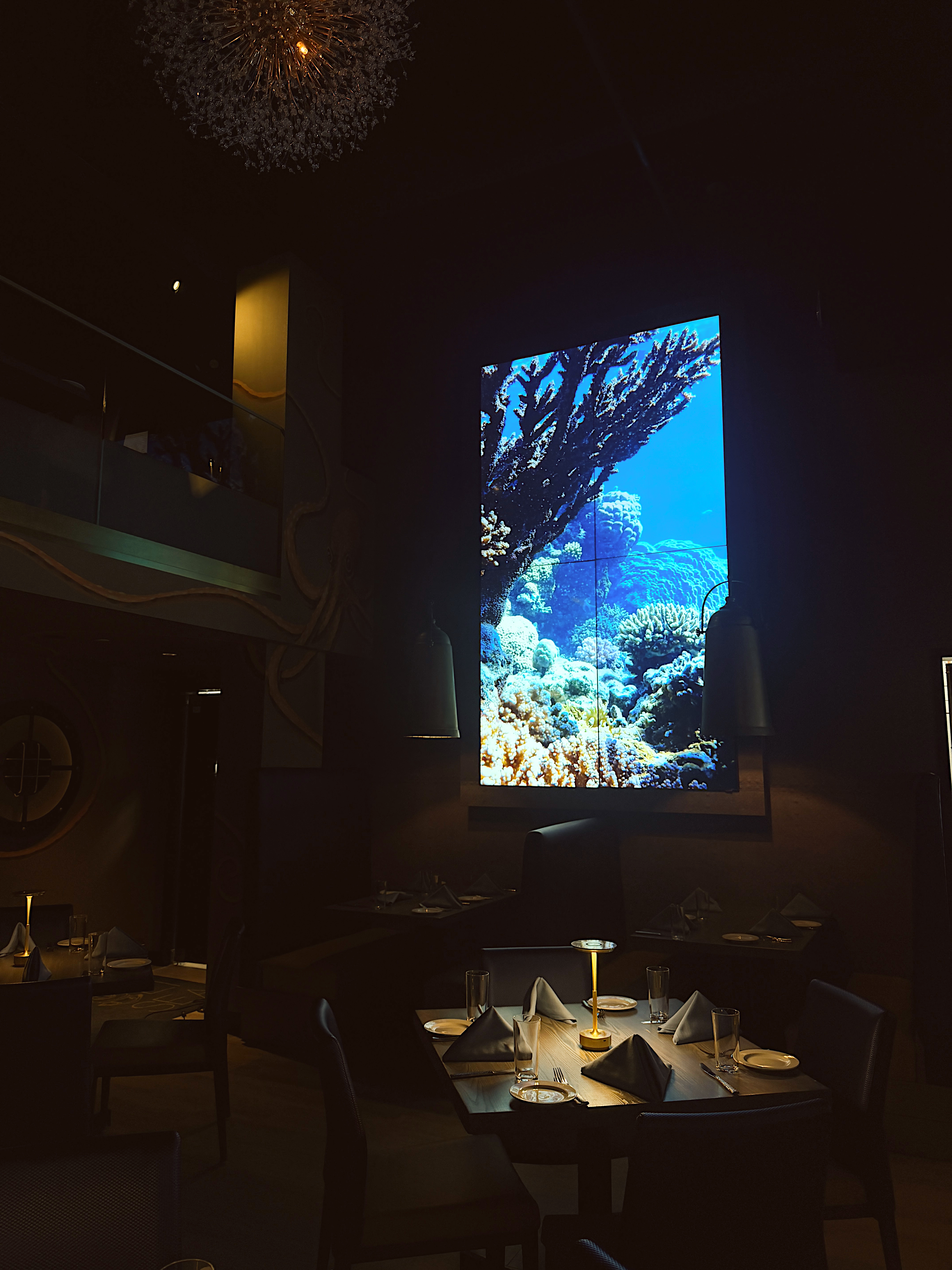 a room with tables and chairs and a large screen