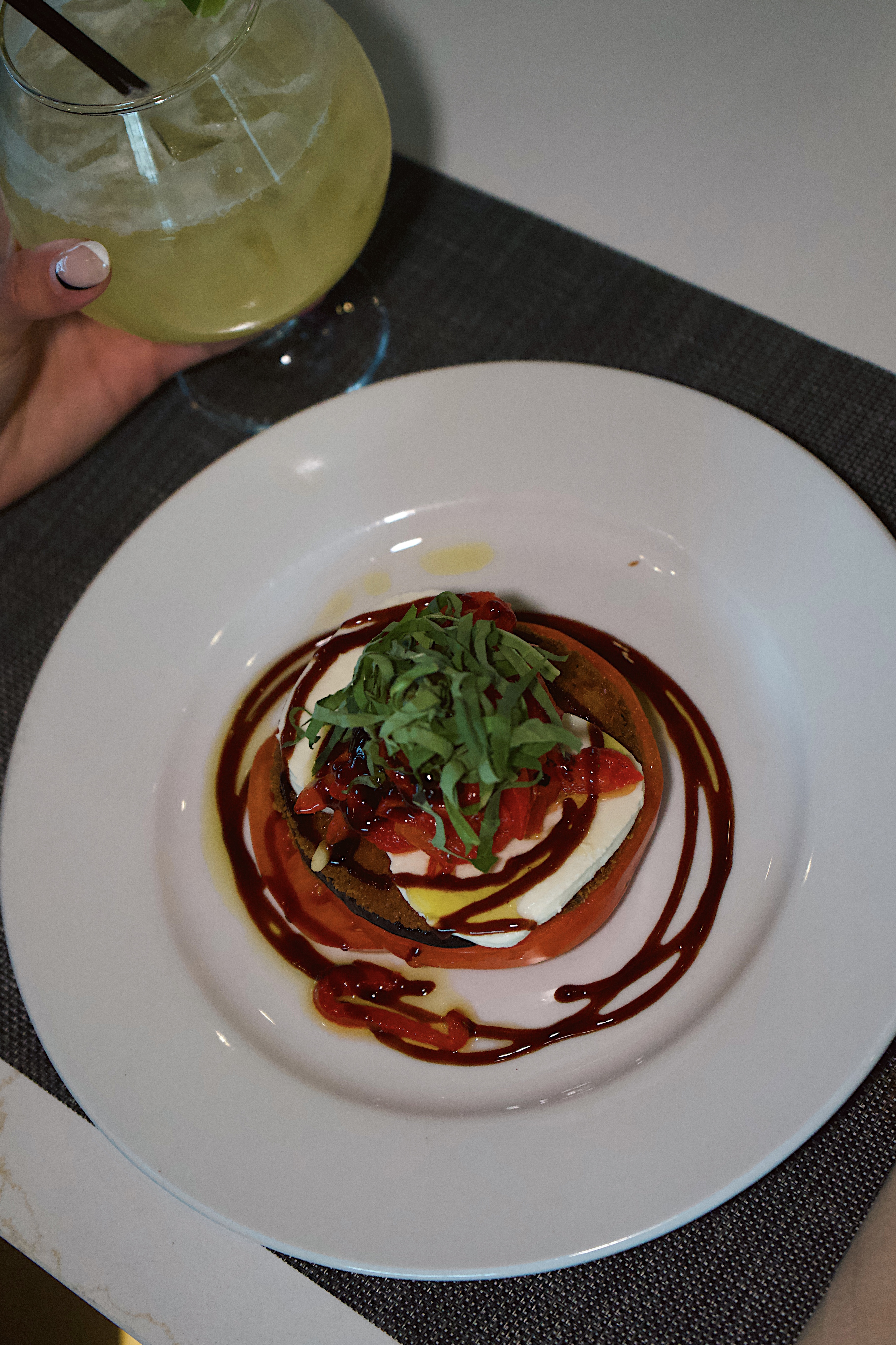 a plate of food with a drink in the background
