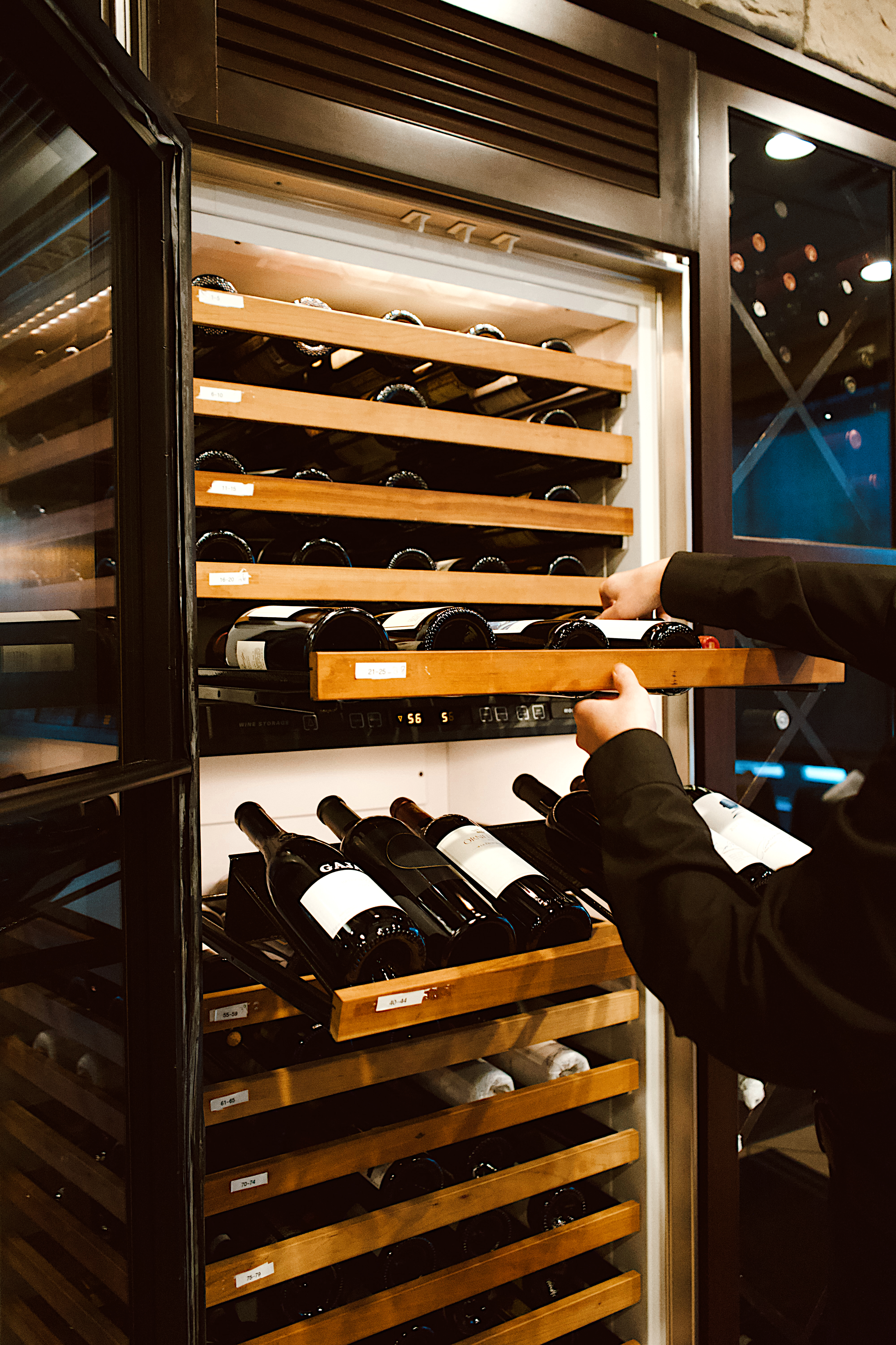 a person opening a wine fridge