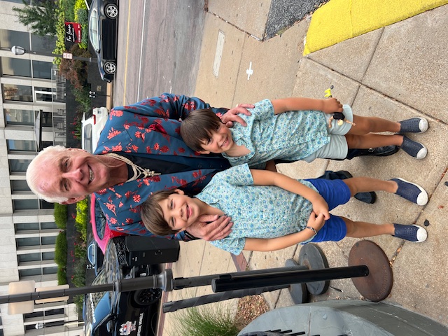 Ric Flair and a little boy standing on a sidewalk