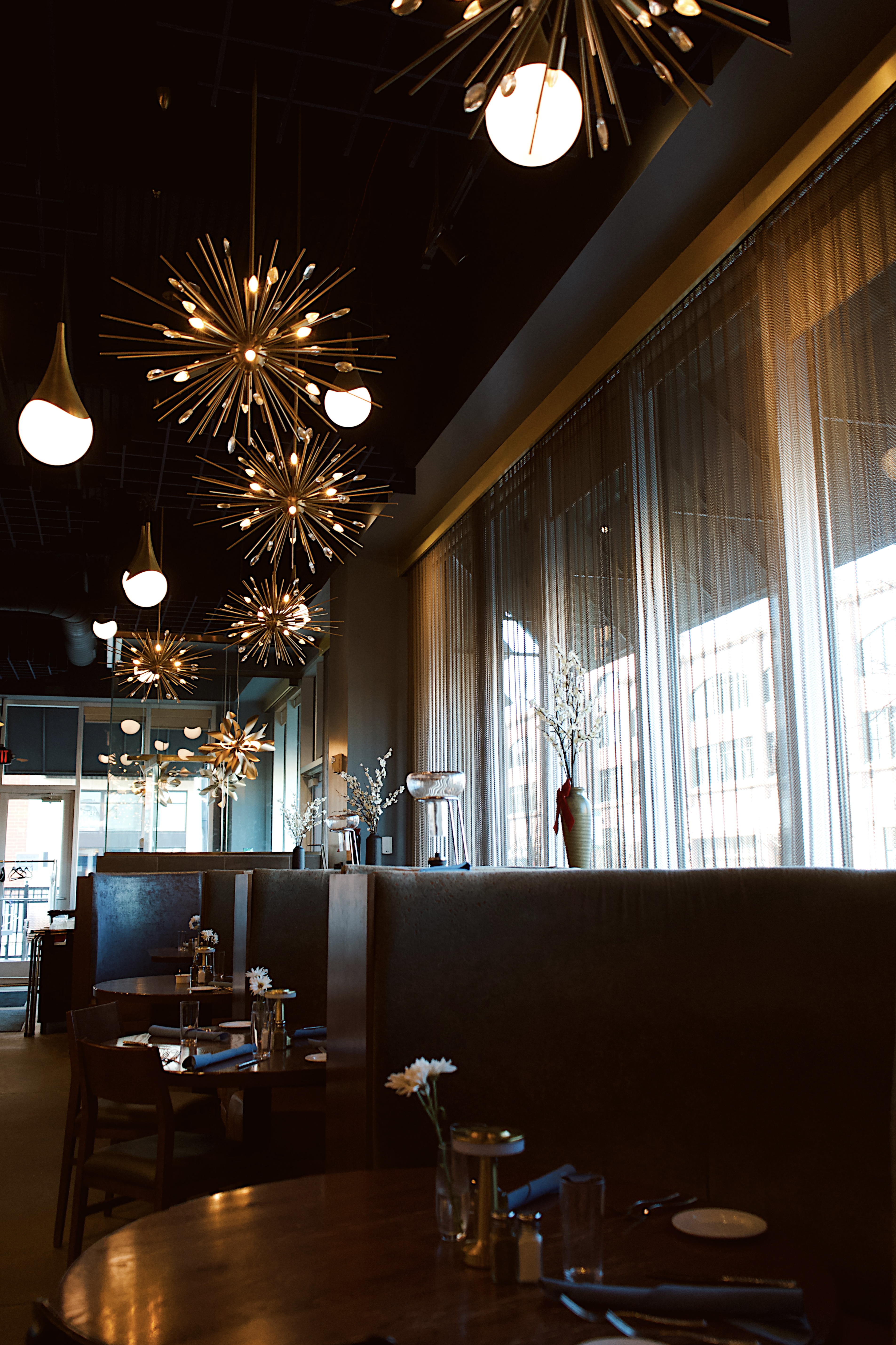 a room with a table and chairs and chandeliers