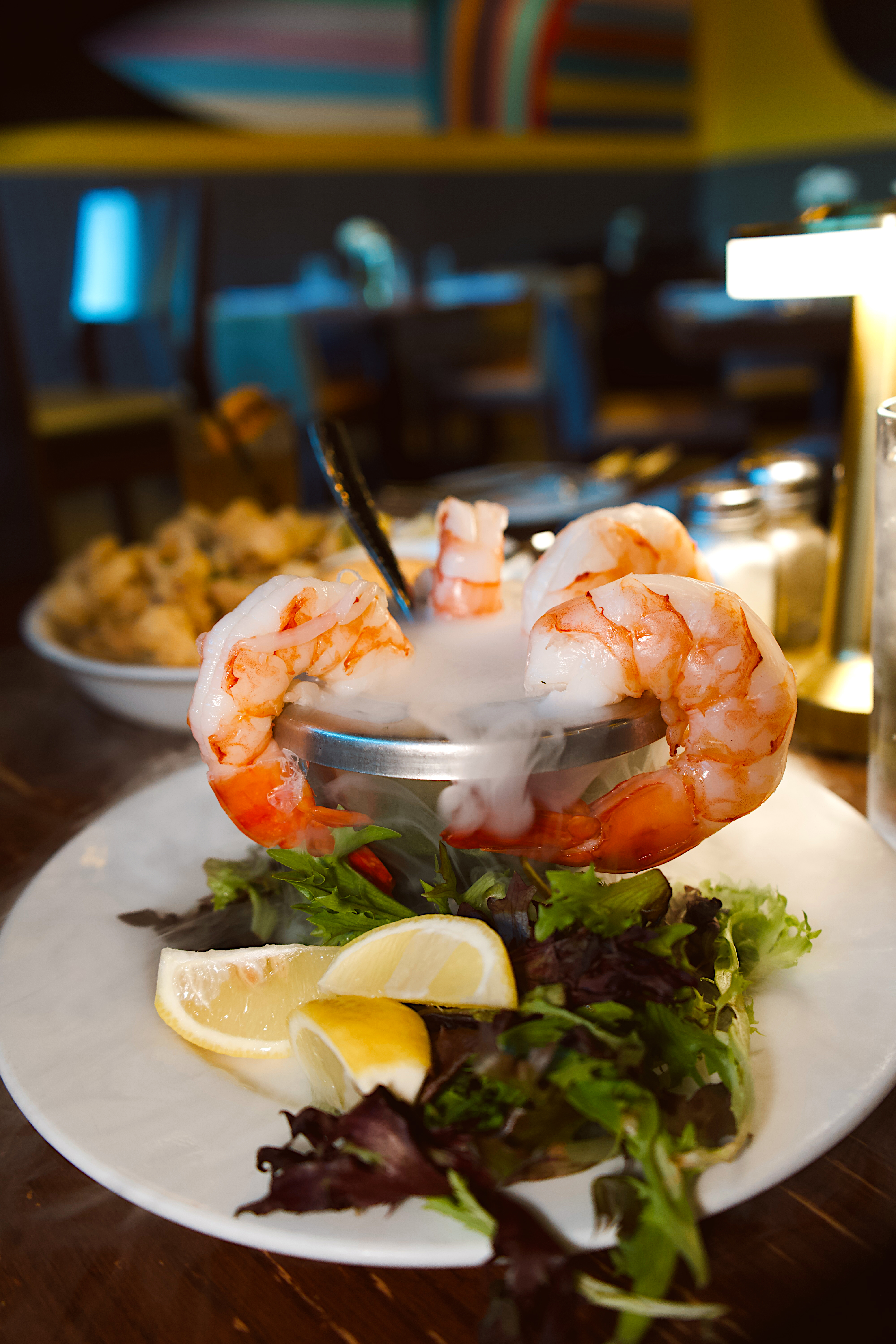 a plate of shrimp with a spoon on top of a plate of food