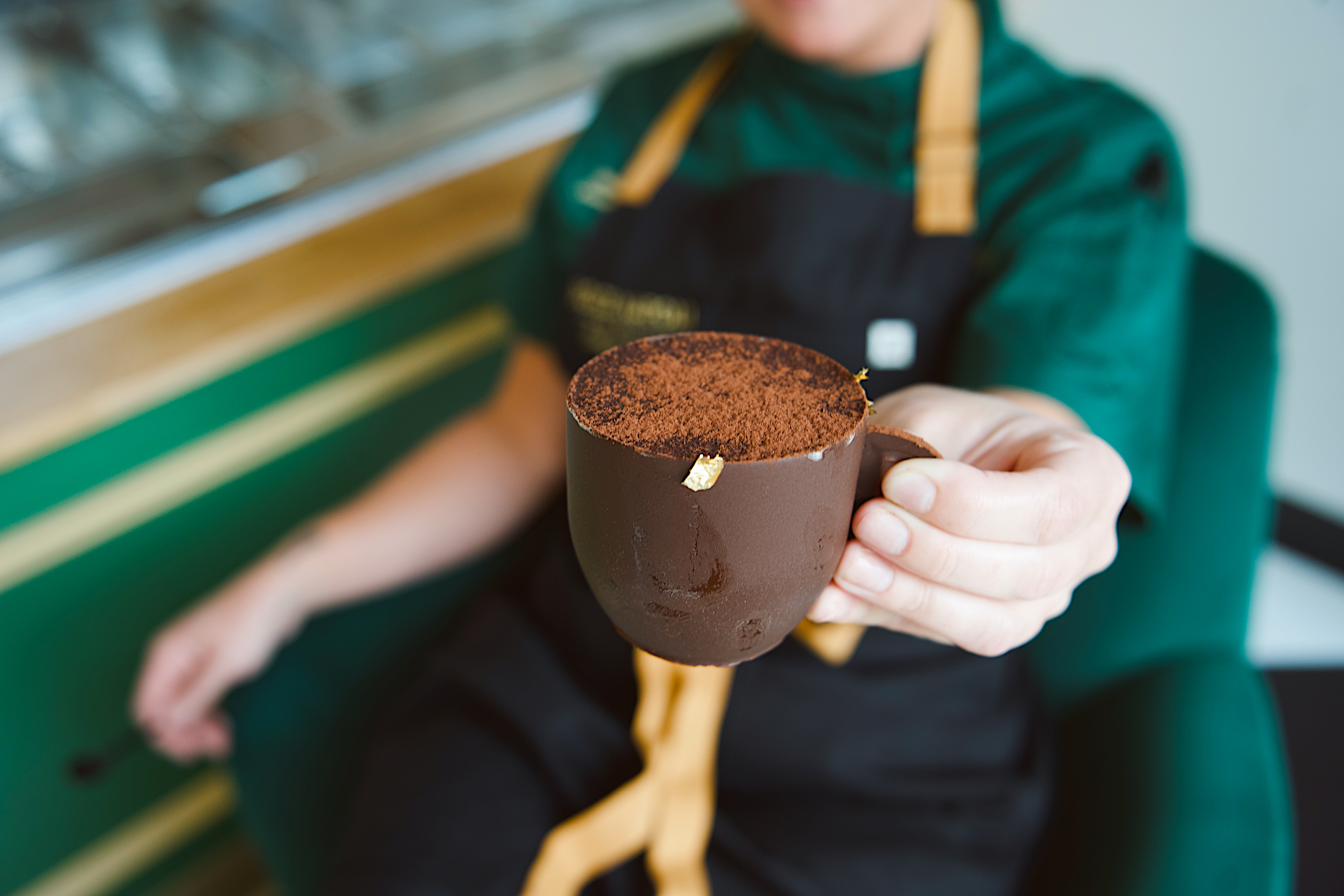 a person holding a cup of chocolate