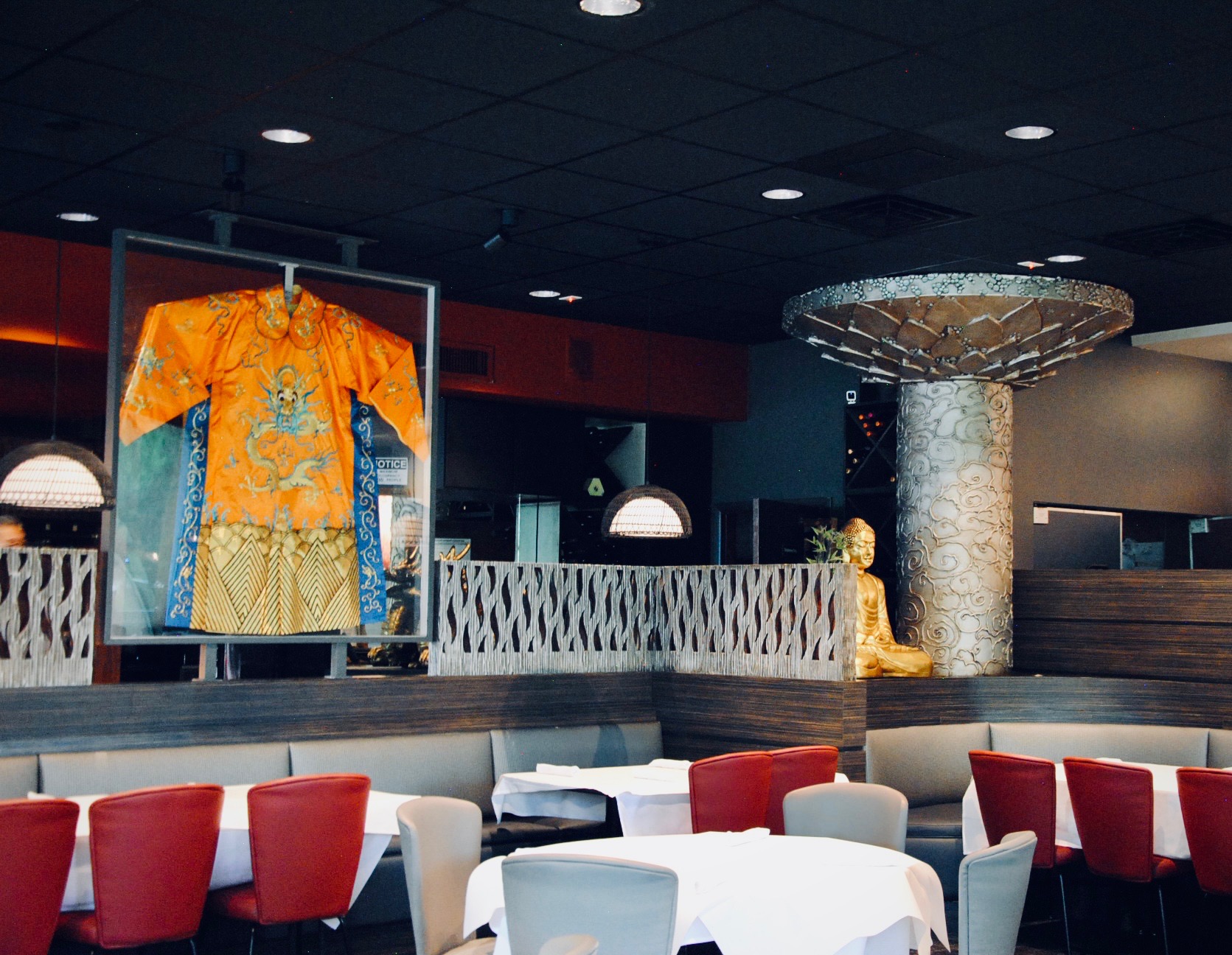 a room with tables and chairs and a statue of a man in a robe