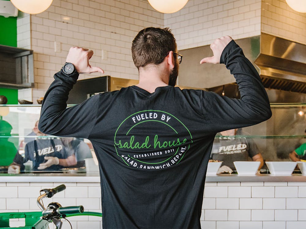 Salad house employee showing up "fueled by Salad House" shirt