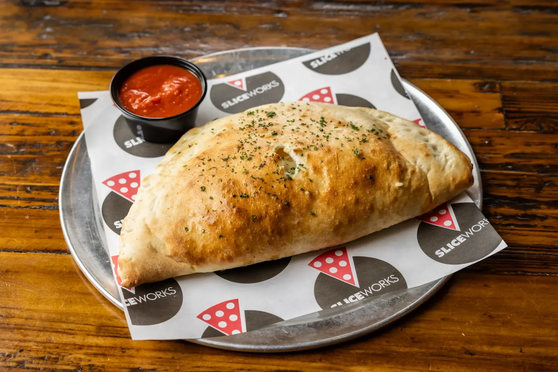 a calzone on a tray with sauce