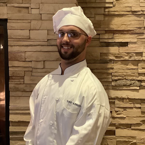 a chef wearing a chef's coat and hat