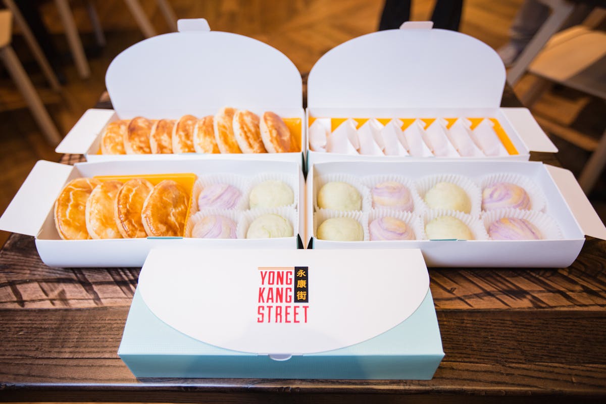 a set of boxes filled with different dumplings and desserts