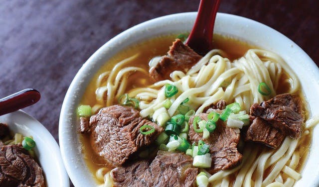 a bowl filled with meat and ramen