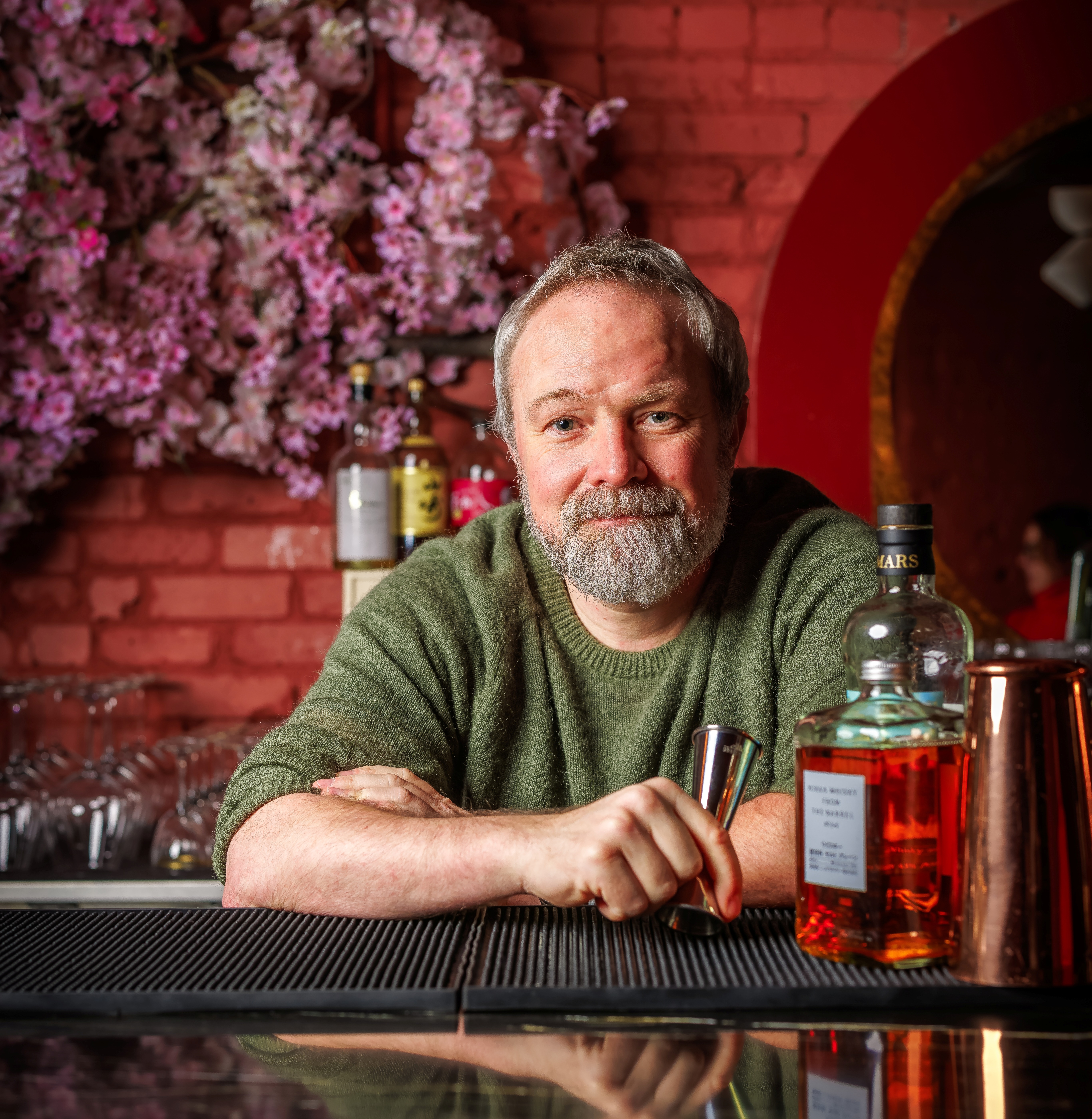 a man sitting at a table with wine glasses