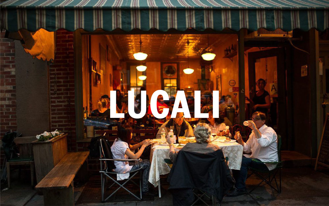 a group of people sitting at a table in front of a building