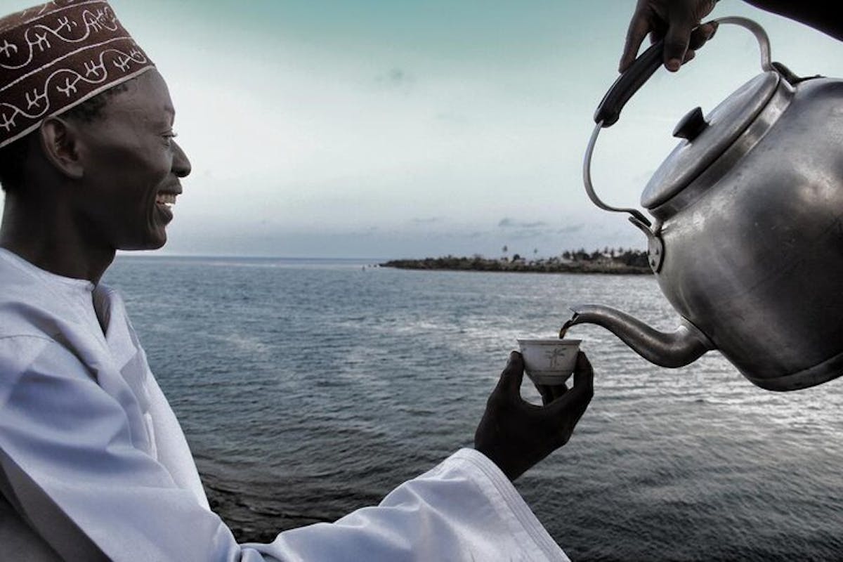 a man standing next to a body of water