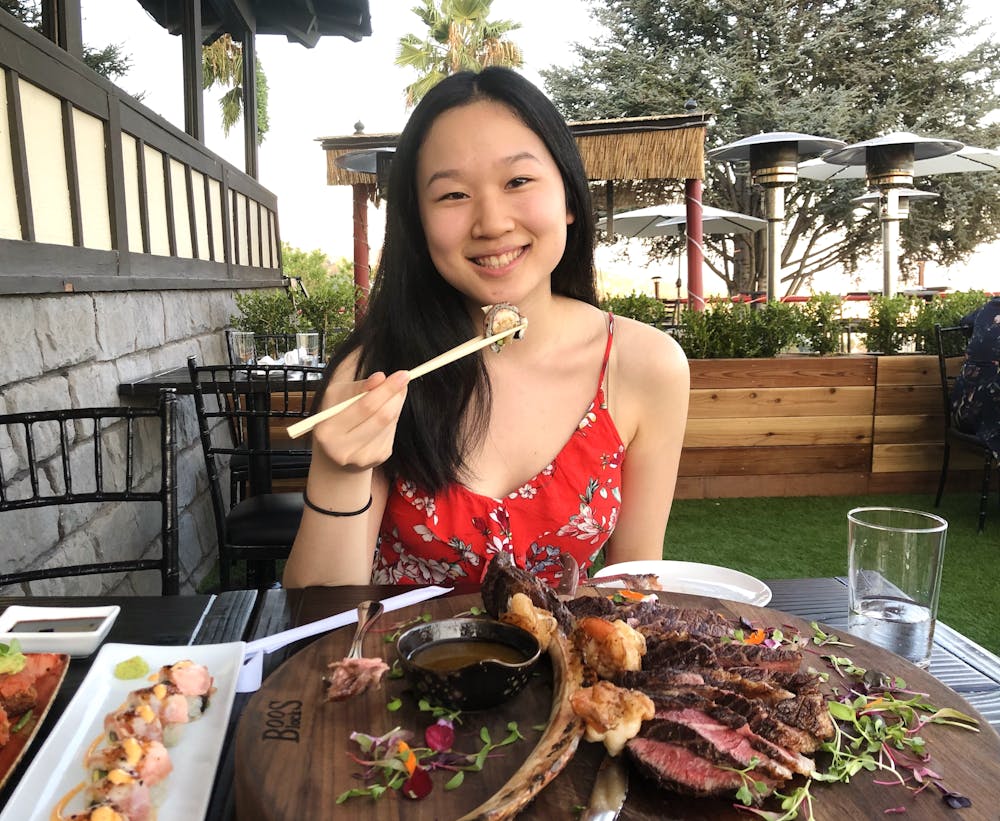 a woman sitting at a table with a plate of food