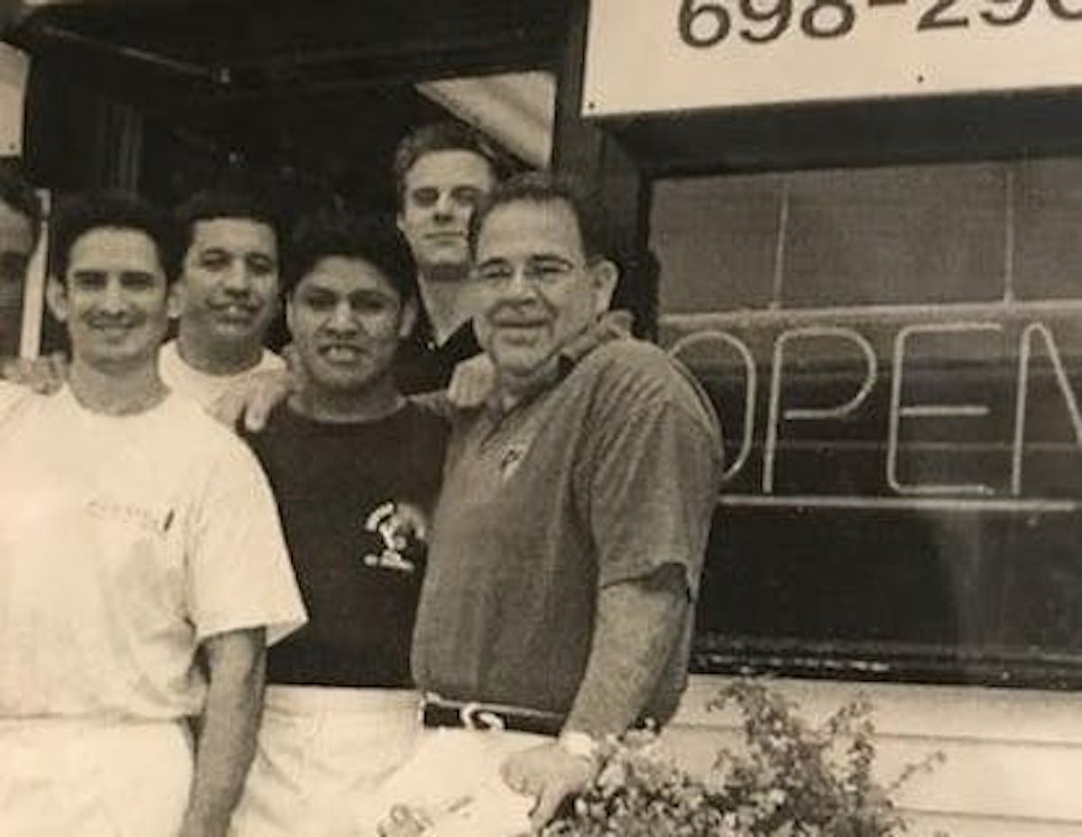 a group of people posing for a photo in front of a restaurant