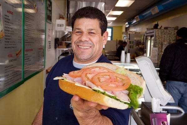 a man holding a sandwich in a restaurant