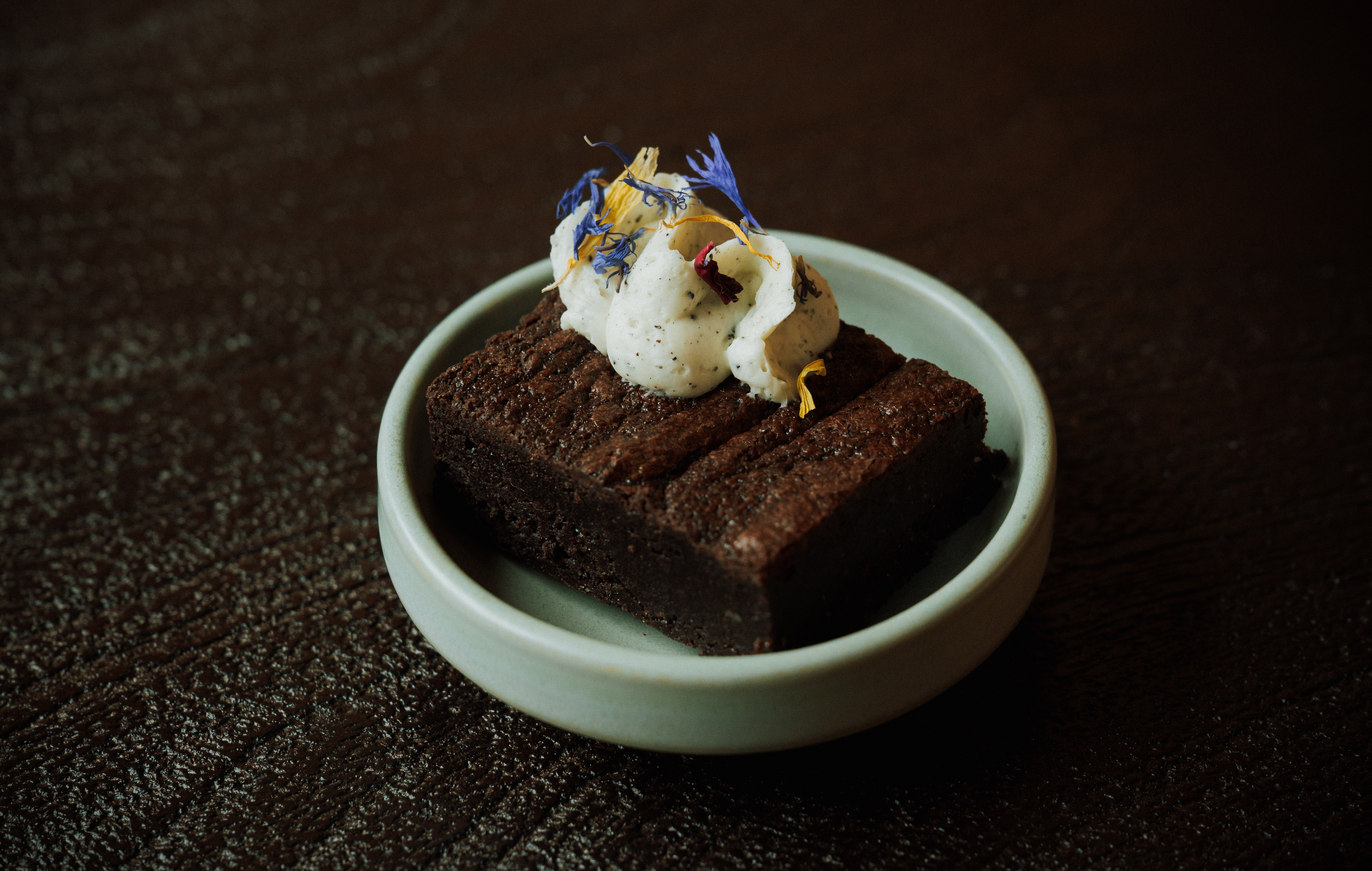 a brownie with whipped cream and flowers on top