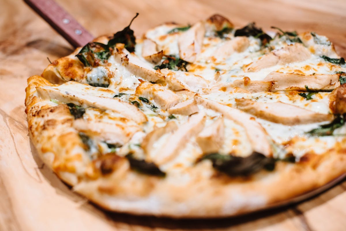 a pizza sitting on top of a wooden cutting board