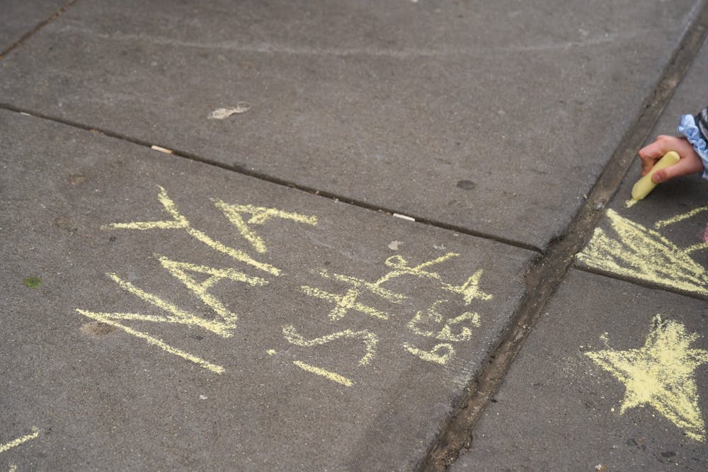 Person writing that Naya is the best on side walk outside of Naya upper west side restaurant 