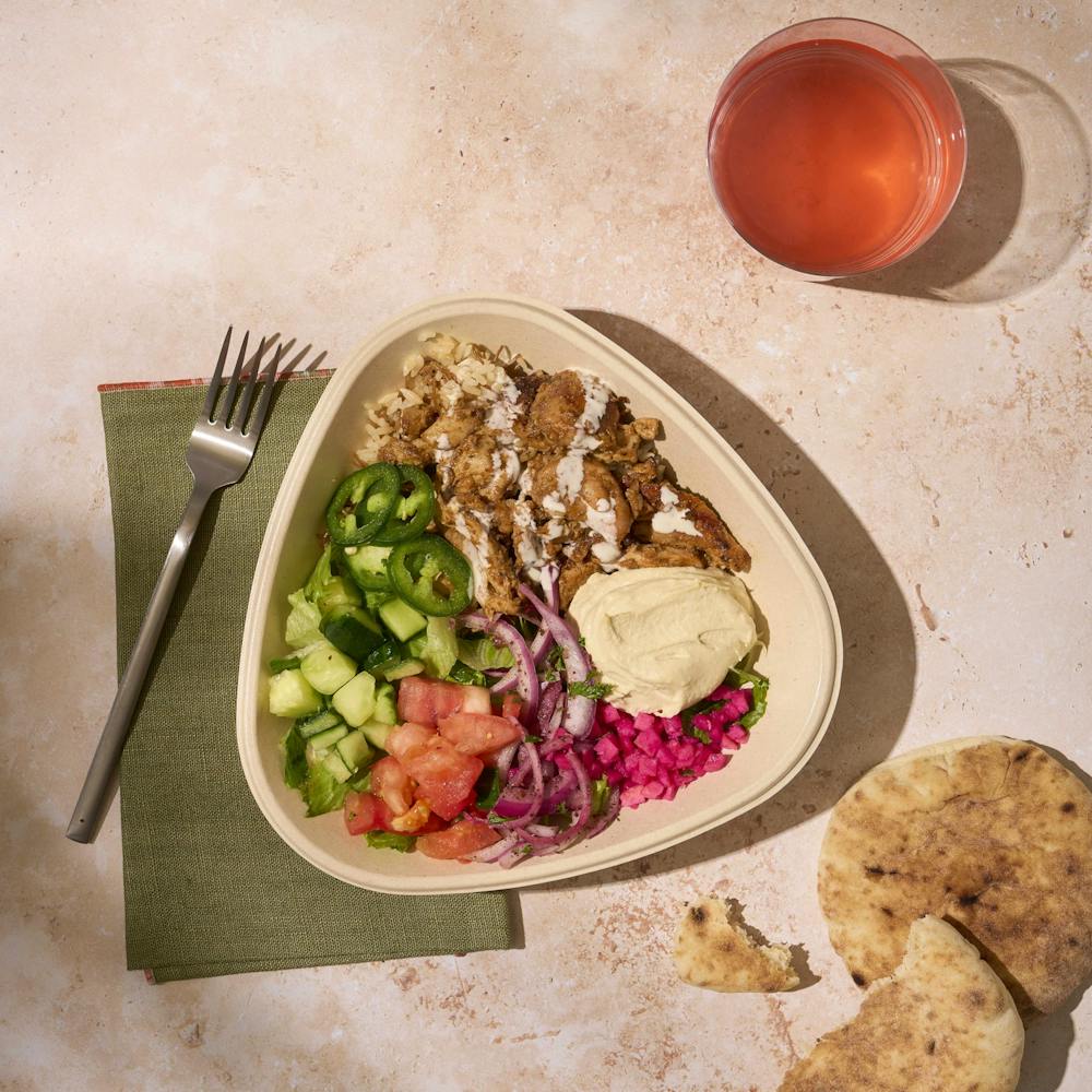 Naya chicken shawarma bowl with hummus, cucumber, tomatoes, sumac onions, pita bread. Pick a protein and unlimited toppings to hit your macro goals. You can see macros on Naya's website nutrition page.