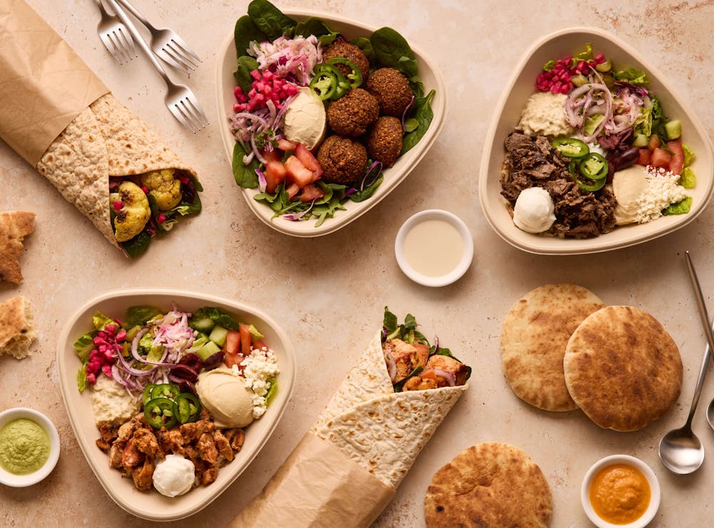 Pictured are bowls, rolls, pita bread and dips available in Naya catering packages to feed your guests. 