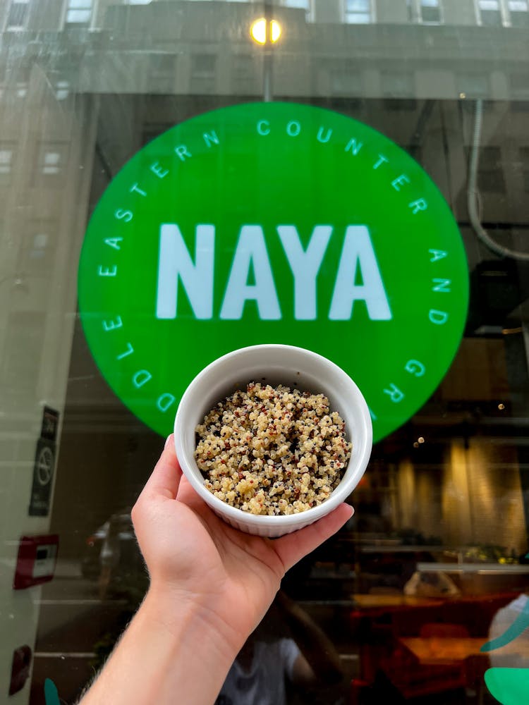 Quinoa bowls in frame outside a Naya store. Naya now offers quinoa as health forward bowl base option.