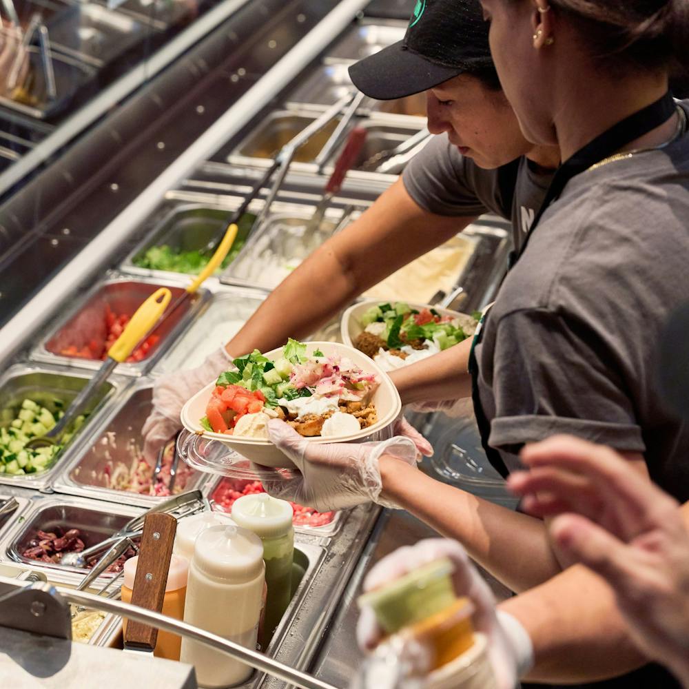 a group of people preparing food in a kitchen