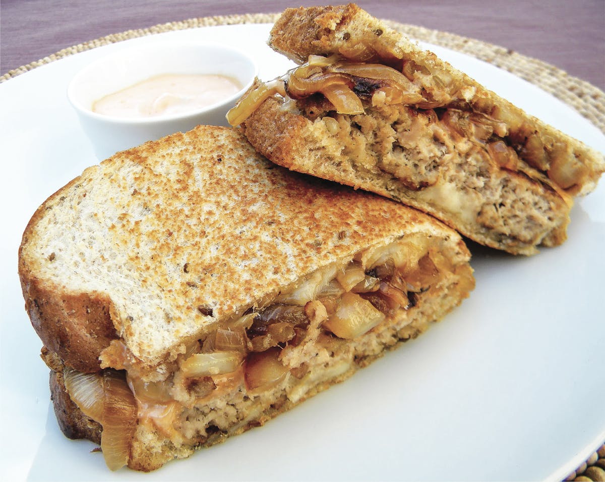 a white plate topped with a sandwich cut in half