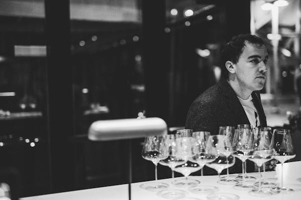 a man sitting at a table with wine glasses