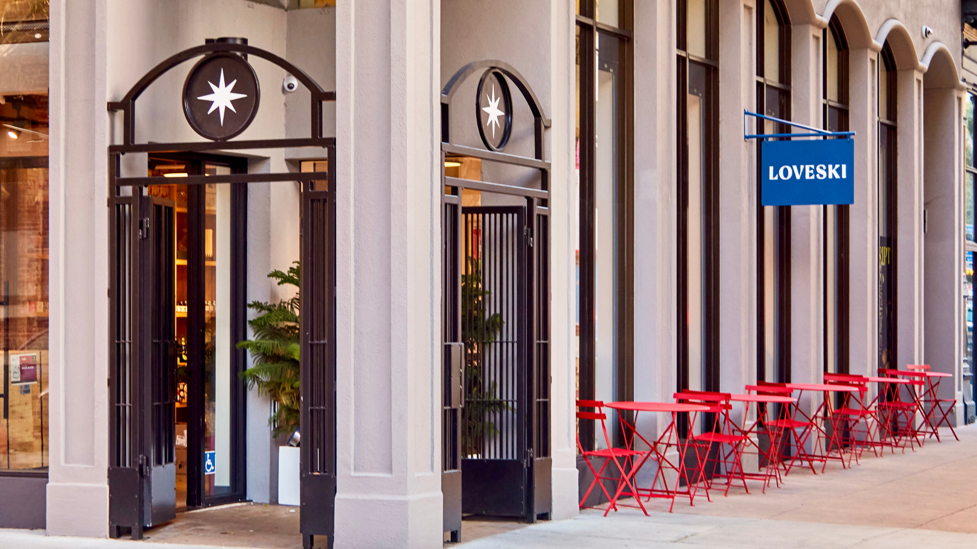 a group of red chairs and tables outside of a building