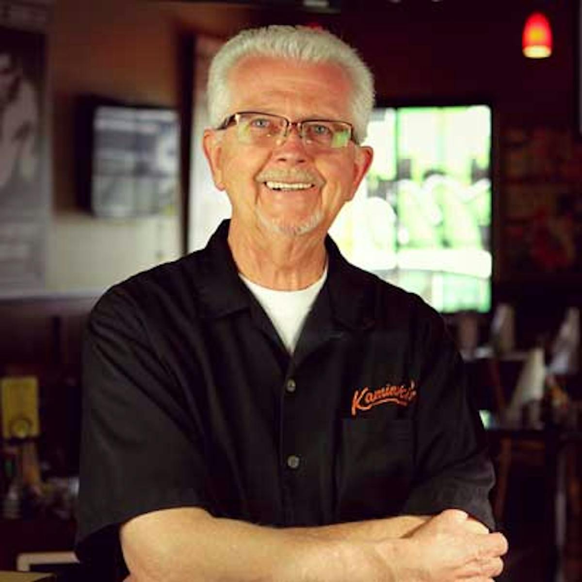 a man wearing glasses and smiling at the camera