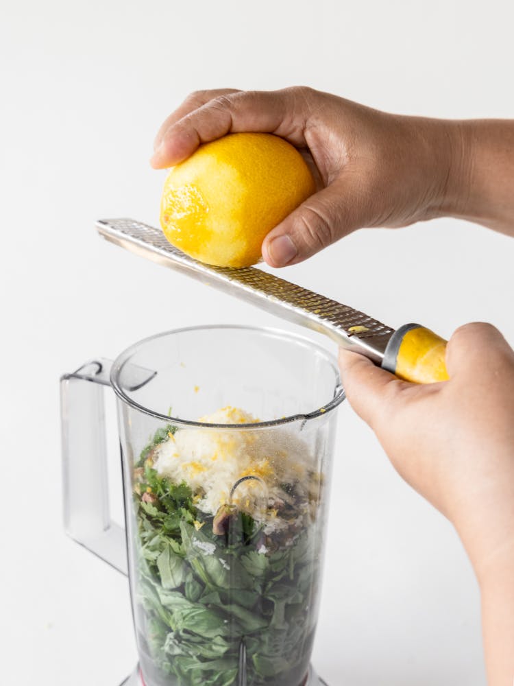 a hand holding a glass of orange juice