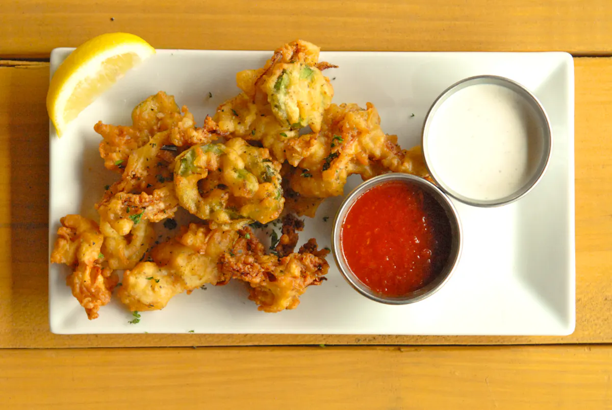 an overview of chicken fingers next to some sauces