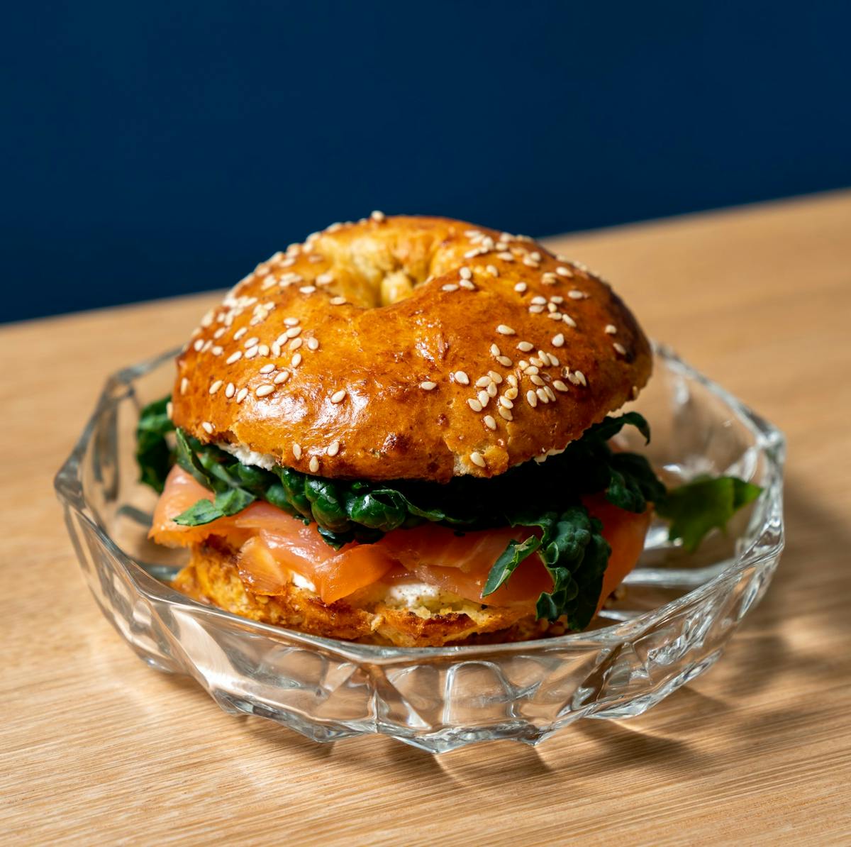 a glass plate topped with a cut in half sandwich sitting on a table