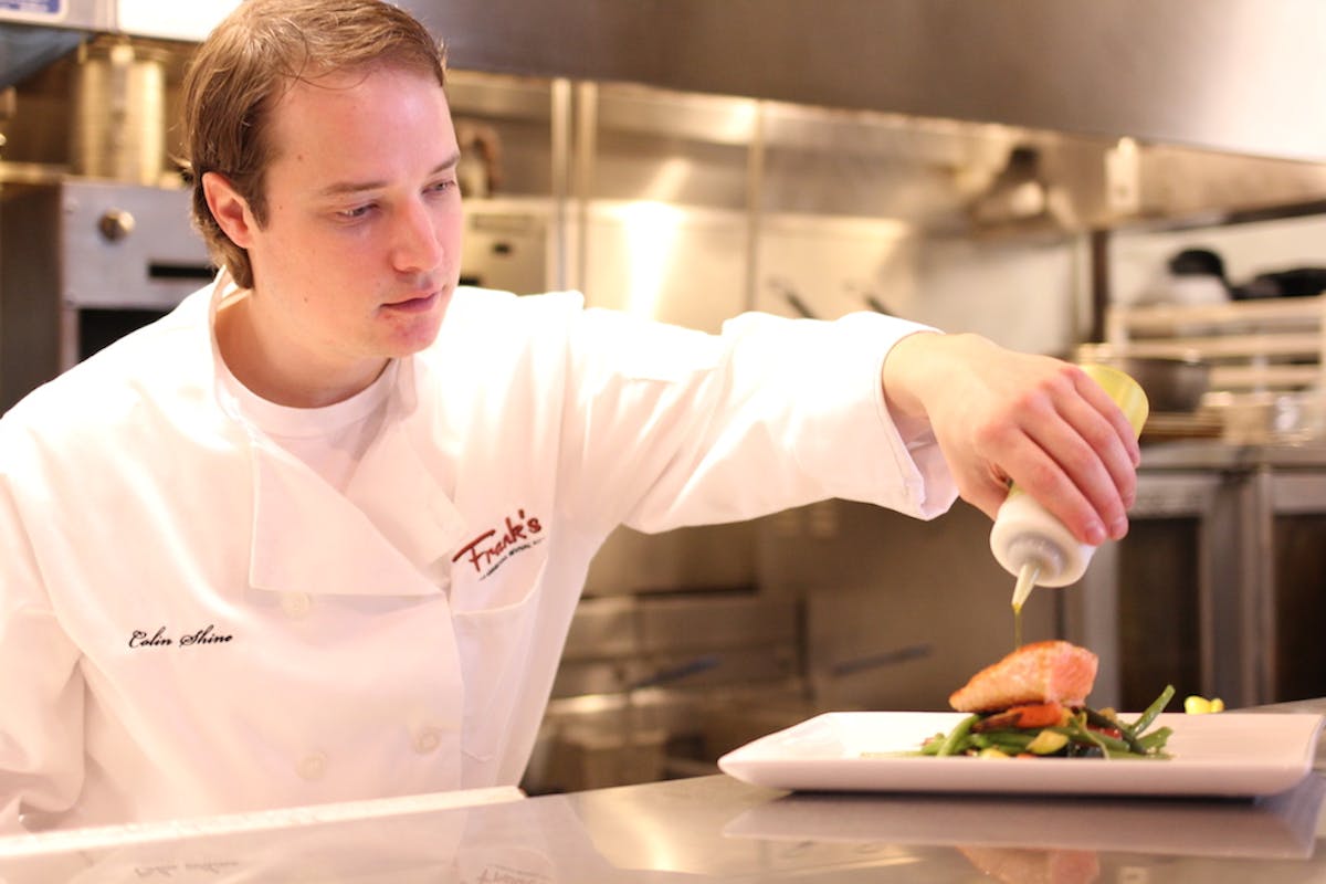 a young man preparing food in a kitchen