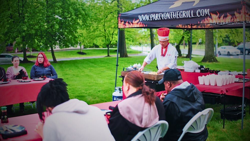 a group of people sitting at a table in a park